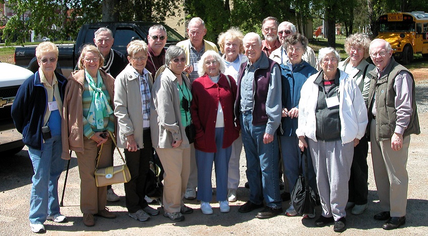 A group of Road Scholars stand with President Jimmy Carter and smile for the camera