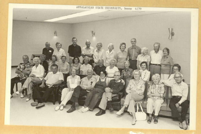 Road Scholars sit and smile for the camera in a black and white photo taken at Appalachian State University