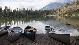 Canoes on the shoreline of a mountain lake