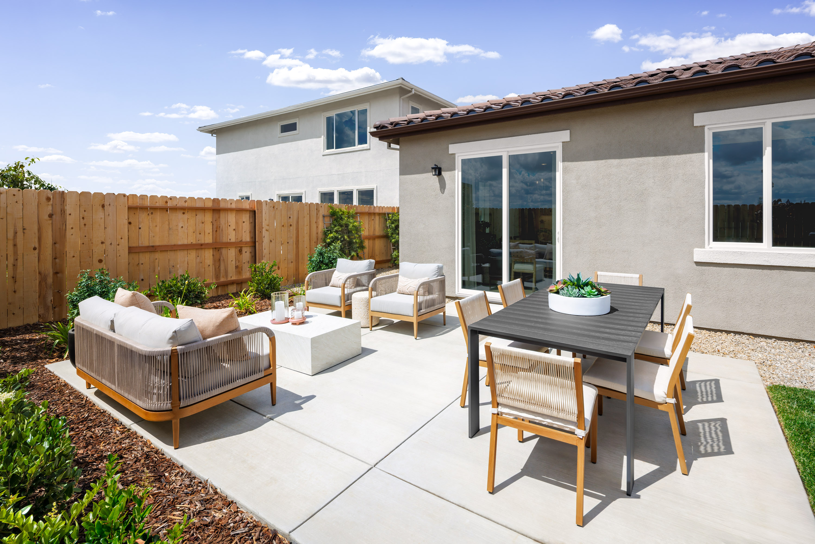 backyard with concrete patio, outdoor conversation & dining furniture, and grass