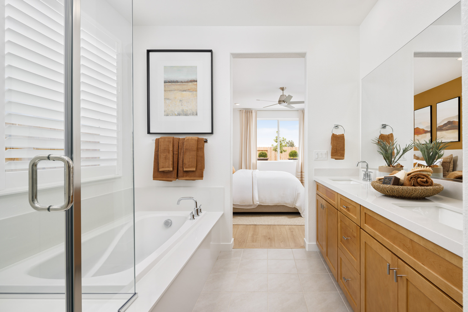 bathroom with light wood cabinets, white counters, two sinks, tub, and shower