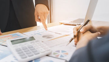 financial papers on a desk in front of two people