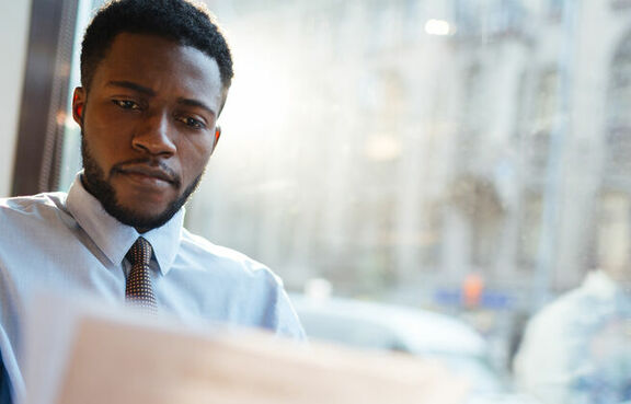 Business man reviewing paperwork in front of a laptop