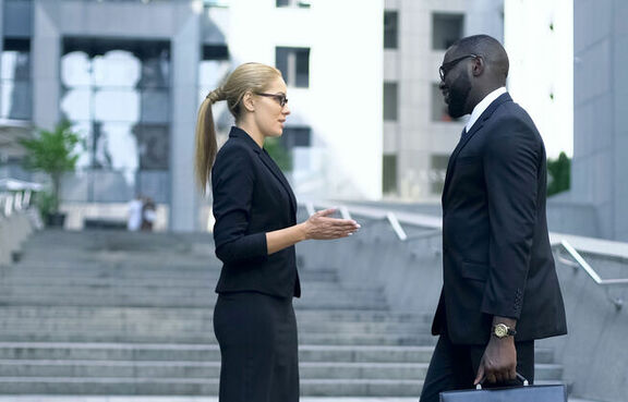 Coworkers talking in from of an office building