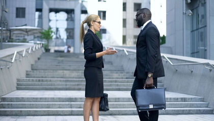 Coworkers talking in from of an office building