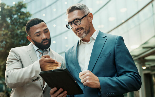 Two businessmen collaborating with tablet