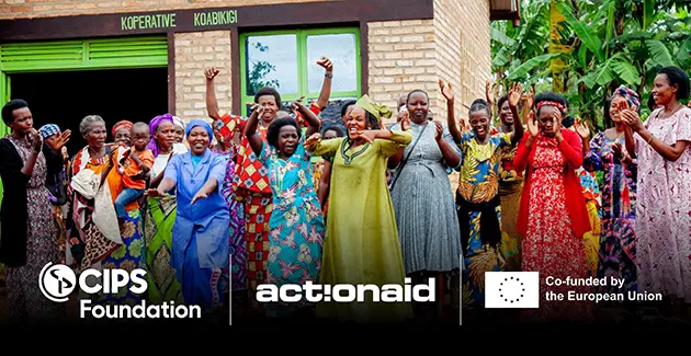 Women farmers from Gisagara District standing in front of their post-harvest warehouse and celebrating their achievements through the project so far.