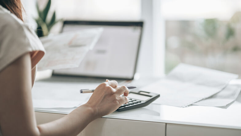 Woman working on laptop and calculator