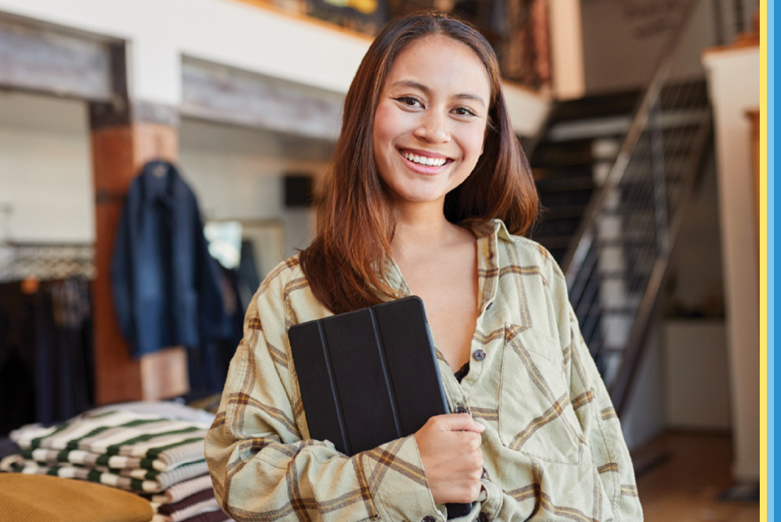 Woman holding iPad smiling at the camera. 