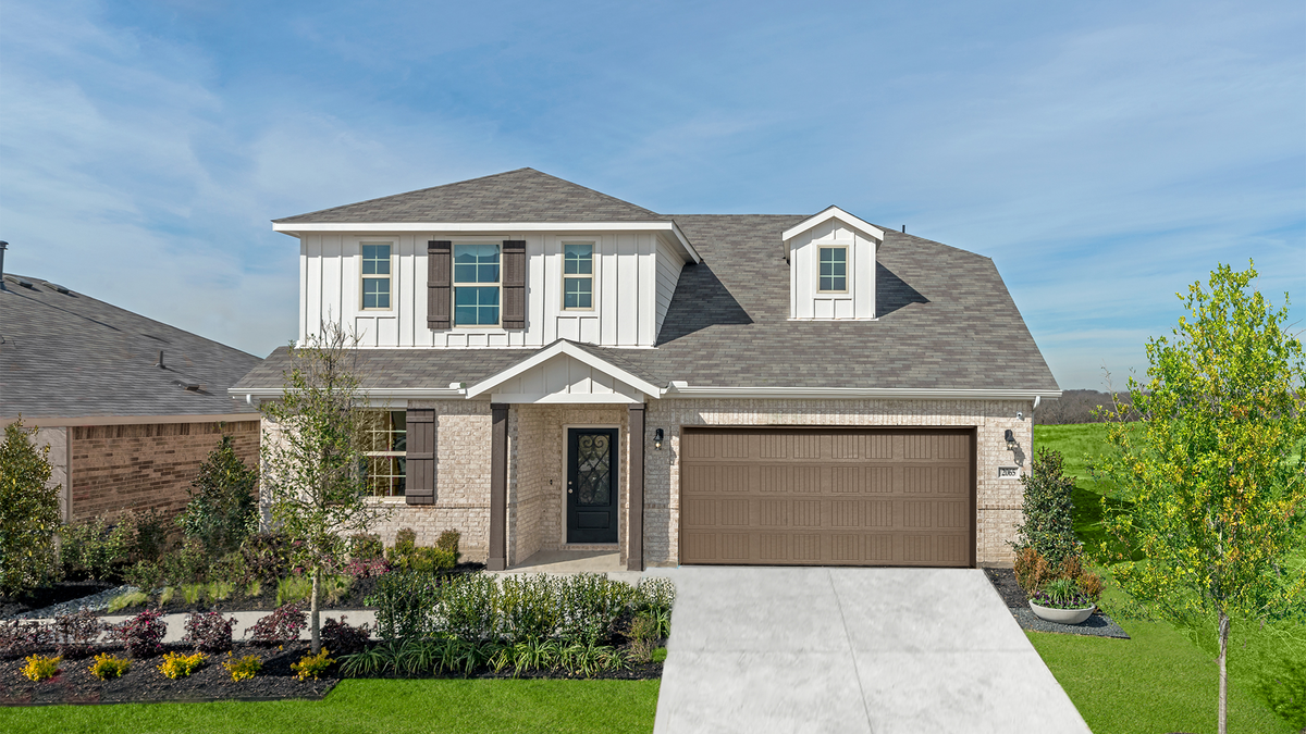 brick exterior with grass front yard and tree