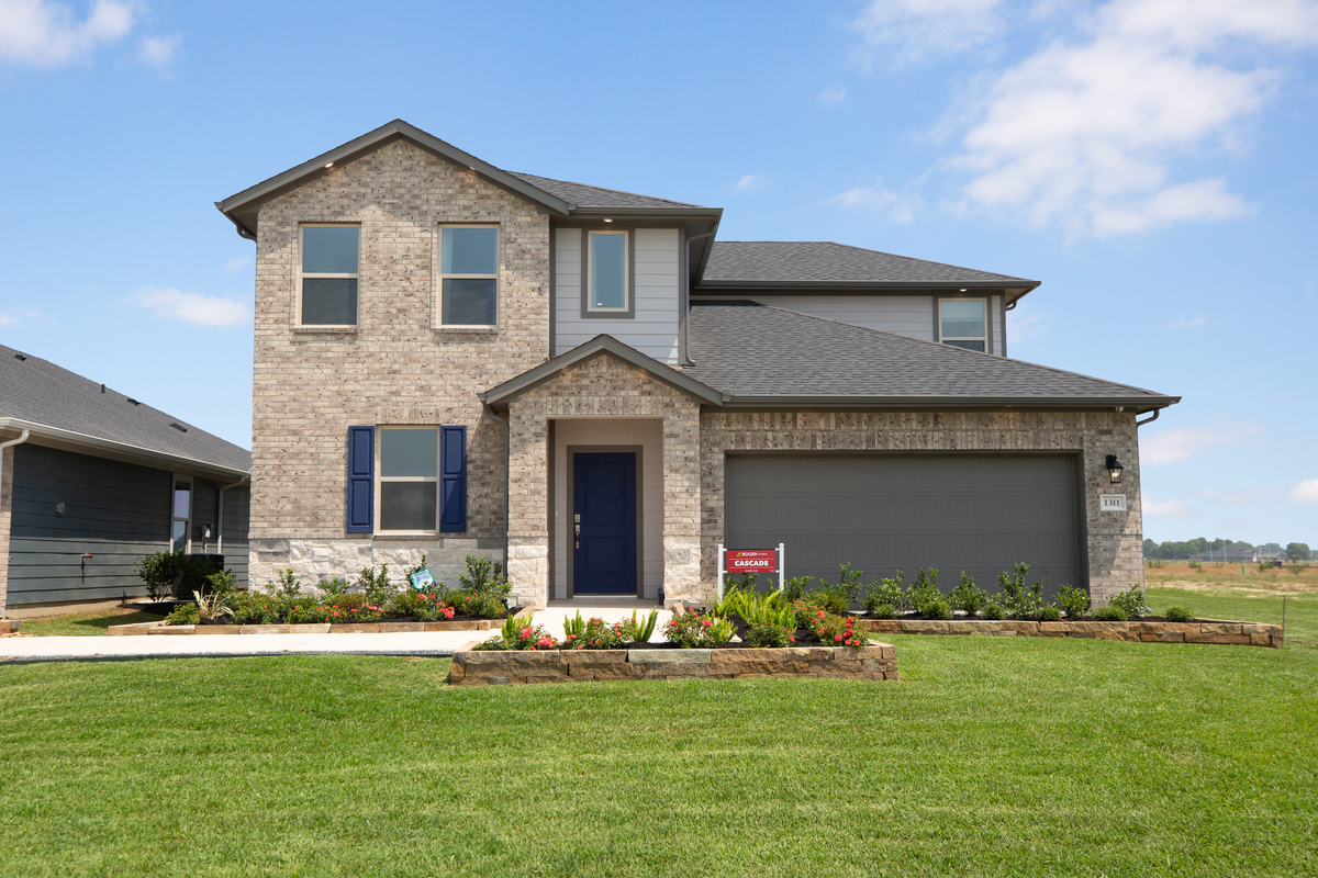 brick and stone exterior with lush landscaping