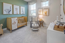 secondary bedroom with green accent wall, wood crib, wall art, and large window