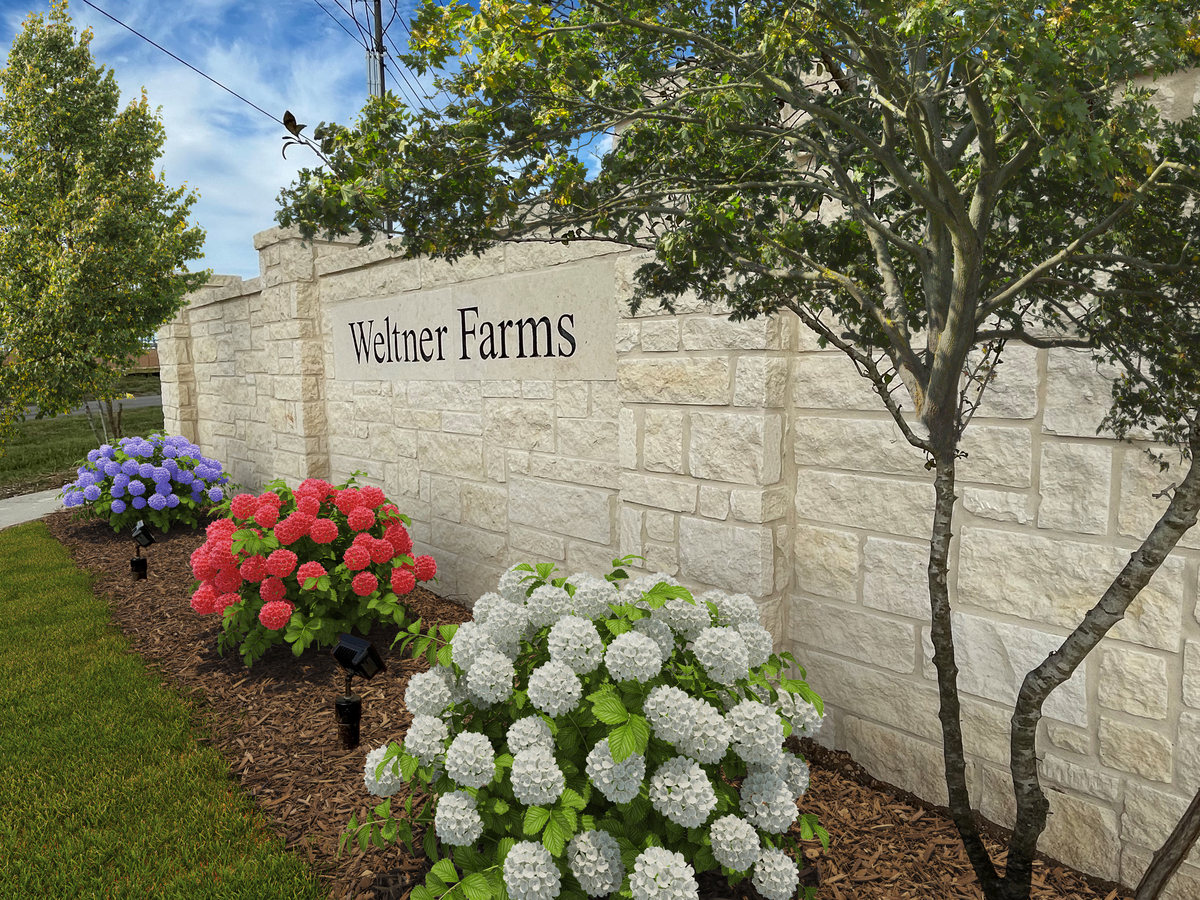 community entrance with a stone sign & trees