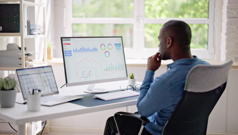 Business man reviewing data graphs on computer