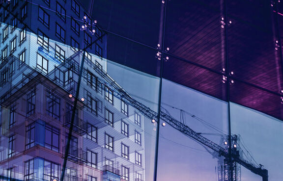 Reflection in a window showing a crane against the sunset