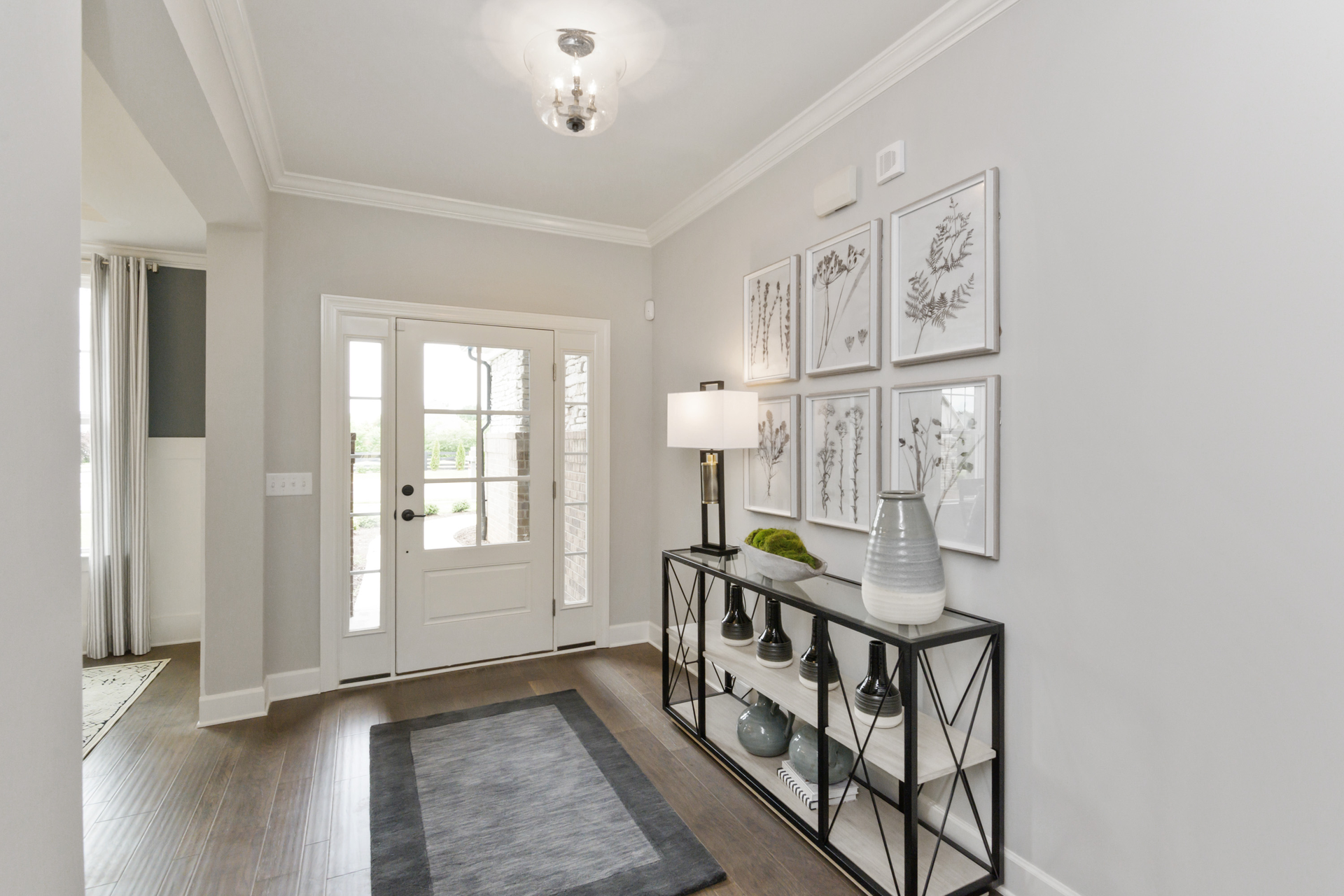 foyer with wood floors, tray ceiling, area rug and entry table