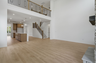 great room with two-story stone fireplace, wood floors, and large windows