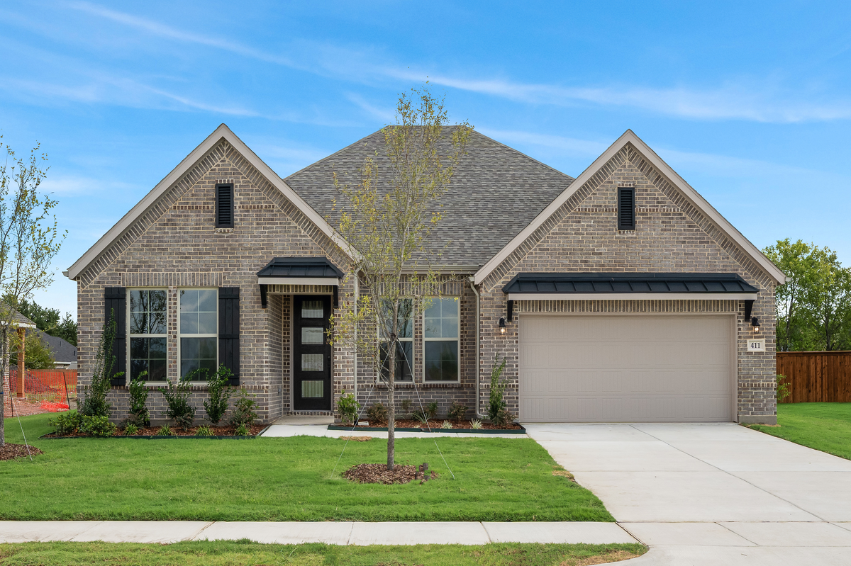 stone and brick exterior with tree in front yard
