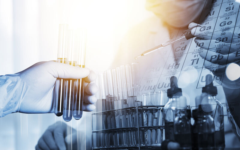 Image of a person holding test tubes in a lab