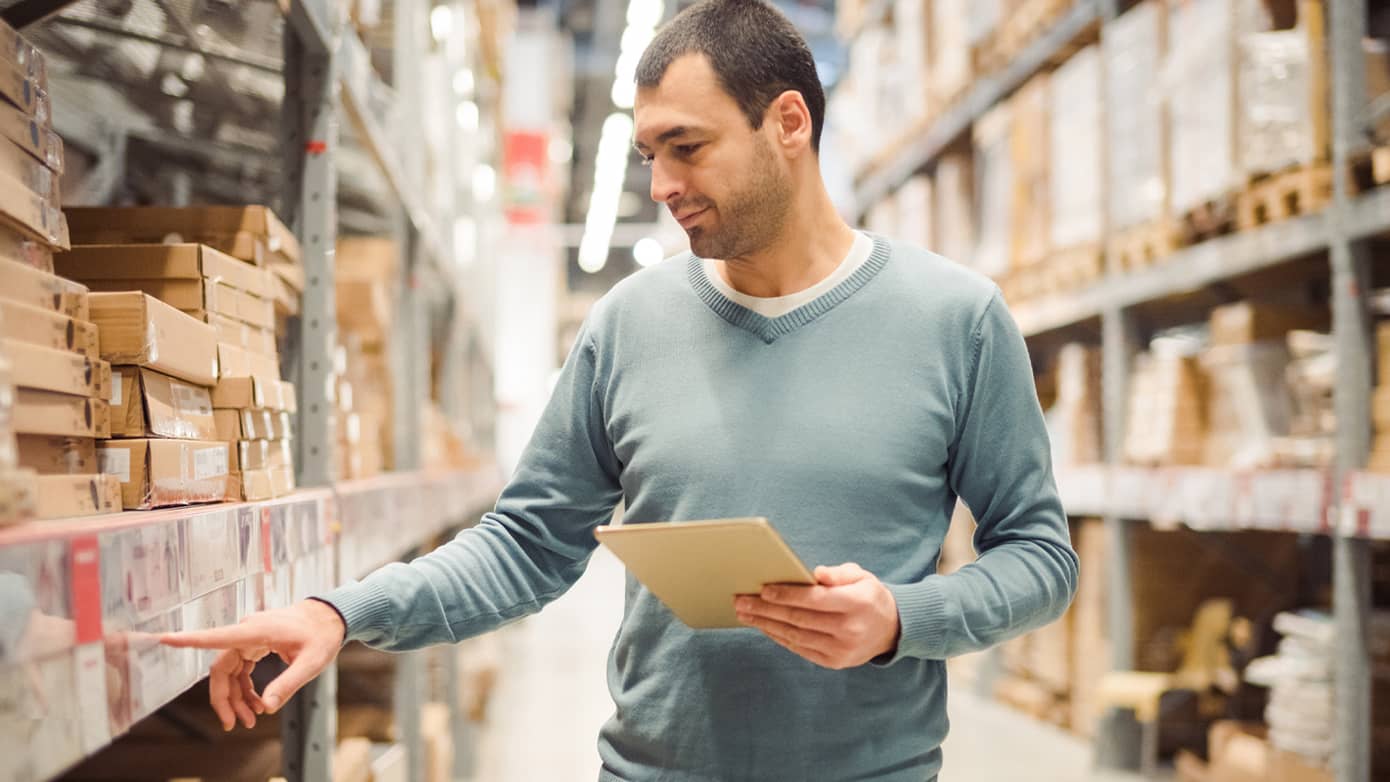 Man taking inventory in warehouse.