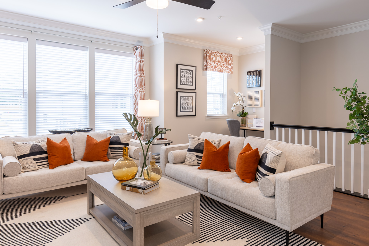 great room with 2 white couches and a rug