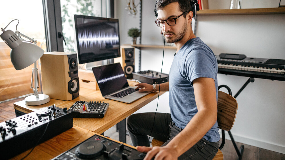 DJ strādā pie dažām dziesmām, valkājot brilles