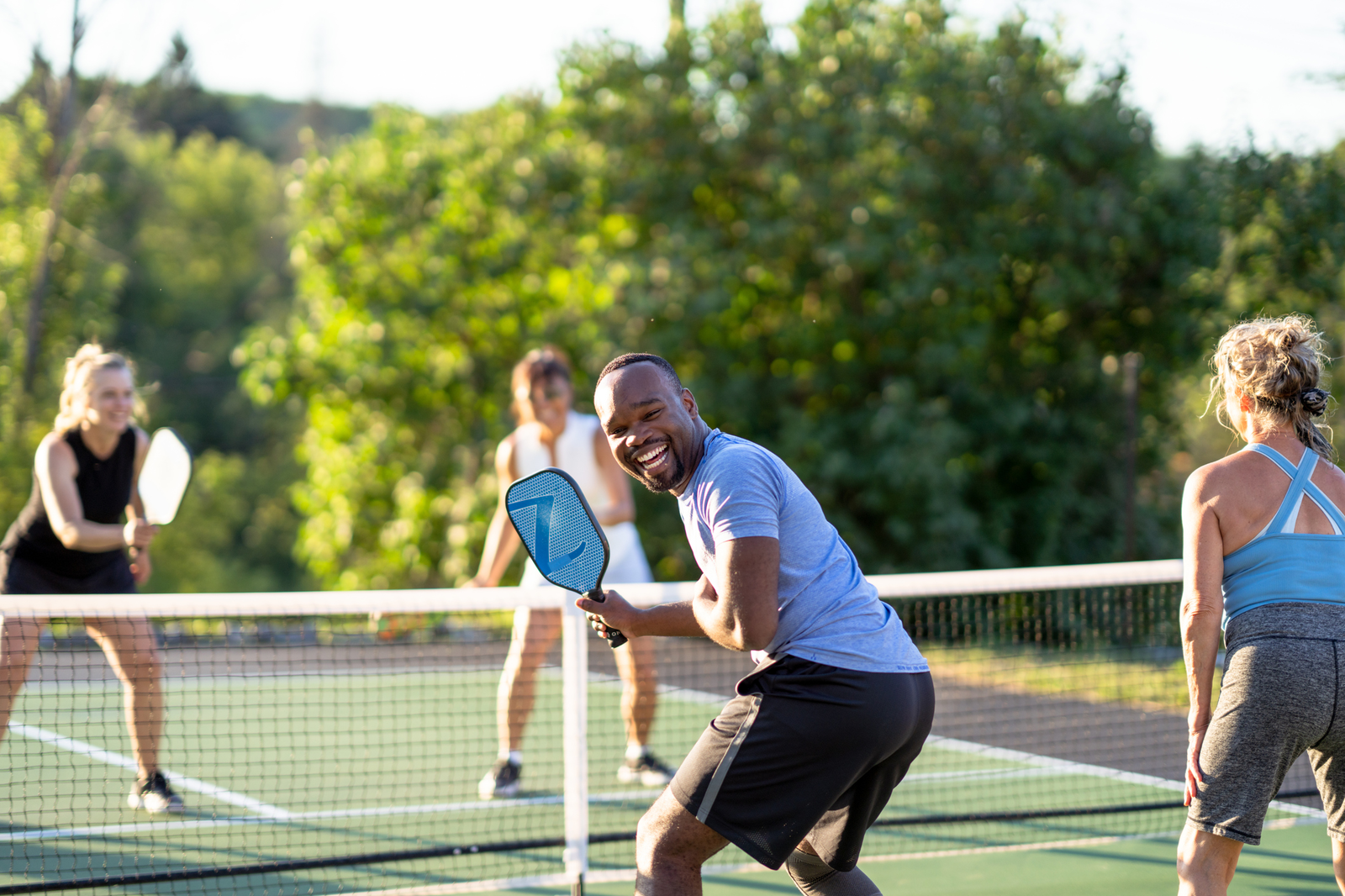 4 people playing pickleball on court