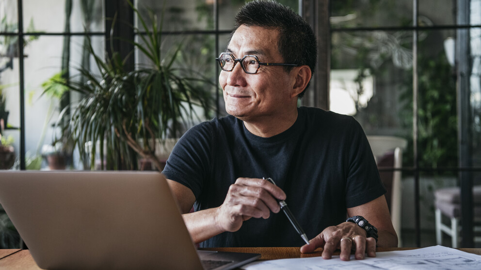 Man with blue light glasses working at a laptop