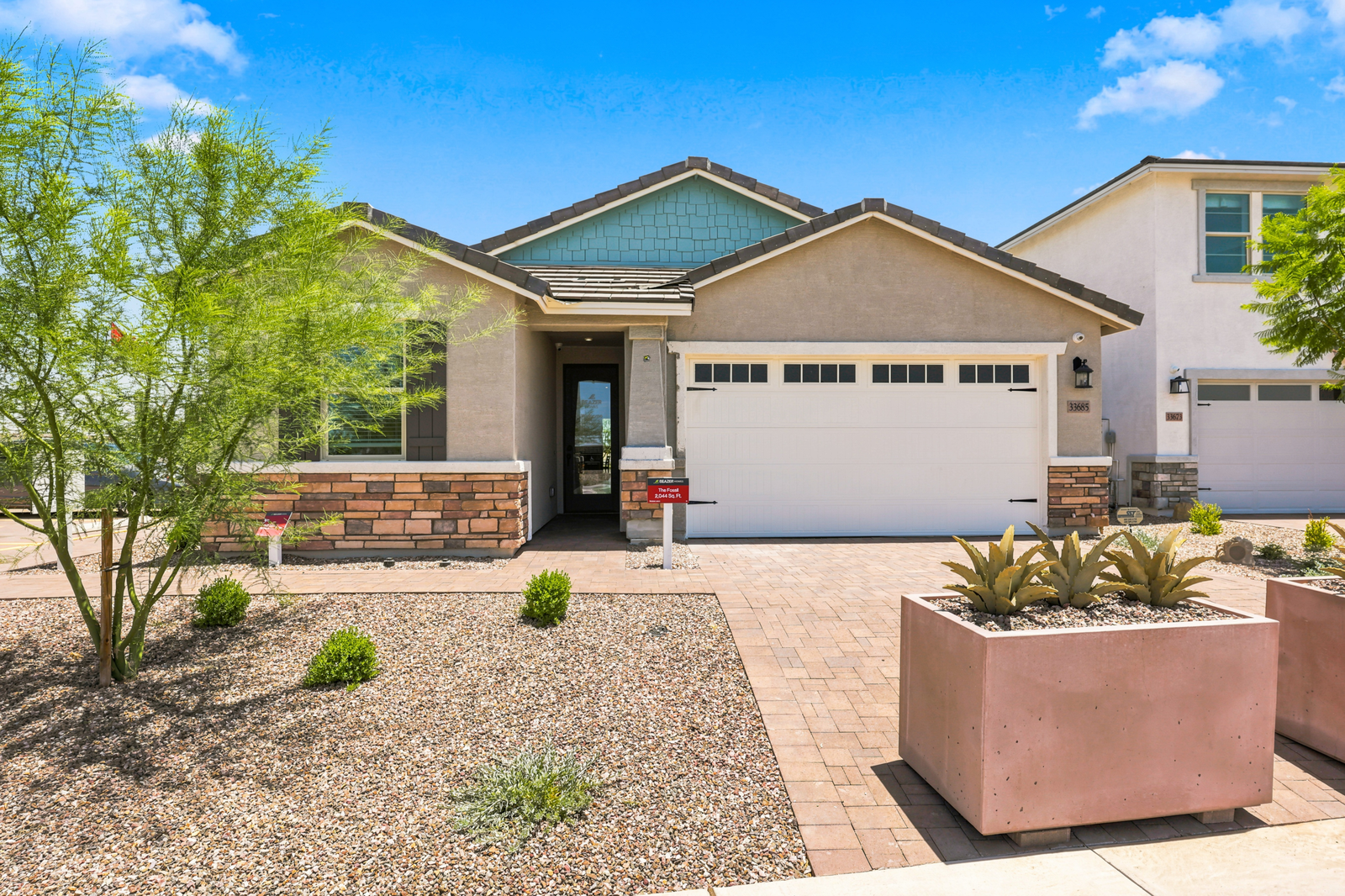 single-story home with paver driveway and desert landscaping