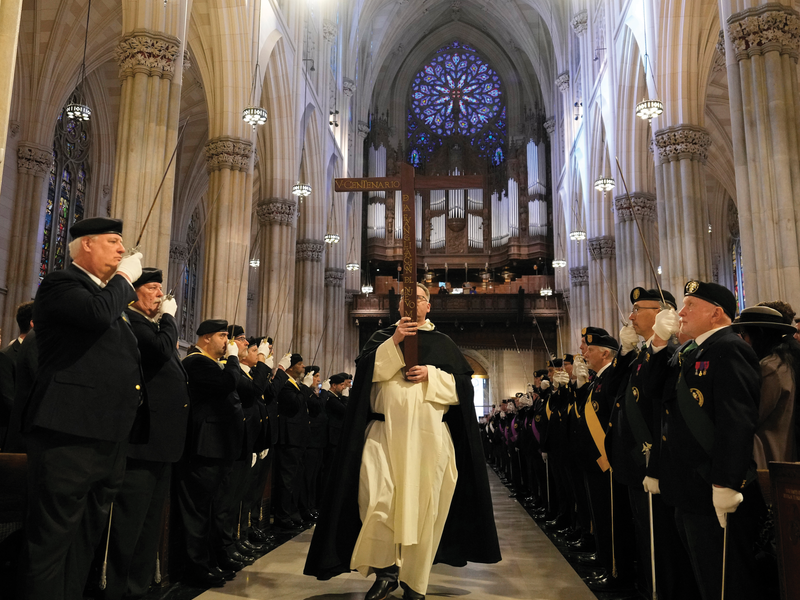 Flanked by Fourth Degree honor guard, Dominican Father Jonathan Kalisch carries a replica Quincentenary Cross of the New World through St. Patrick's Cathedral.