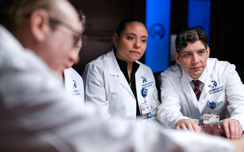 Jose Pimiento, MD, right, looks at a patient's case during the GI tumor board meeting.