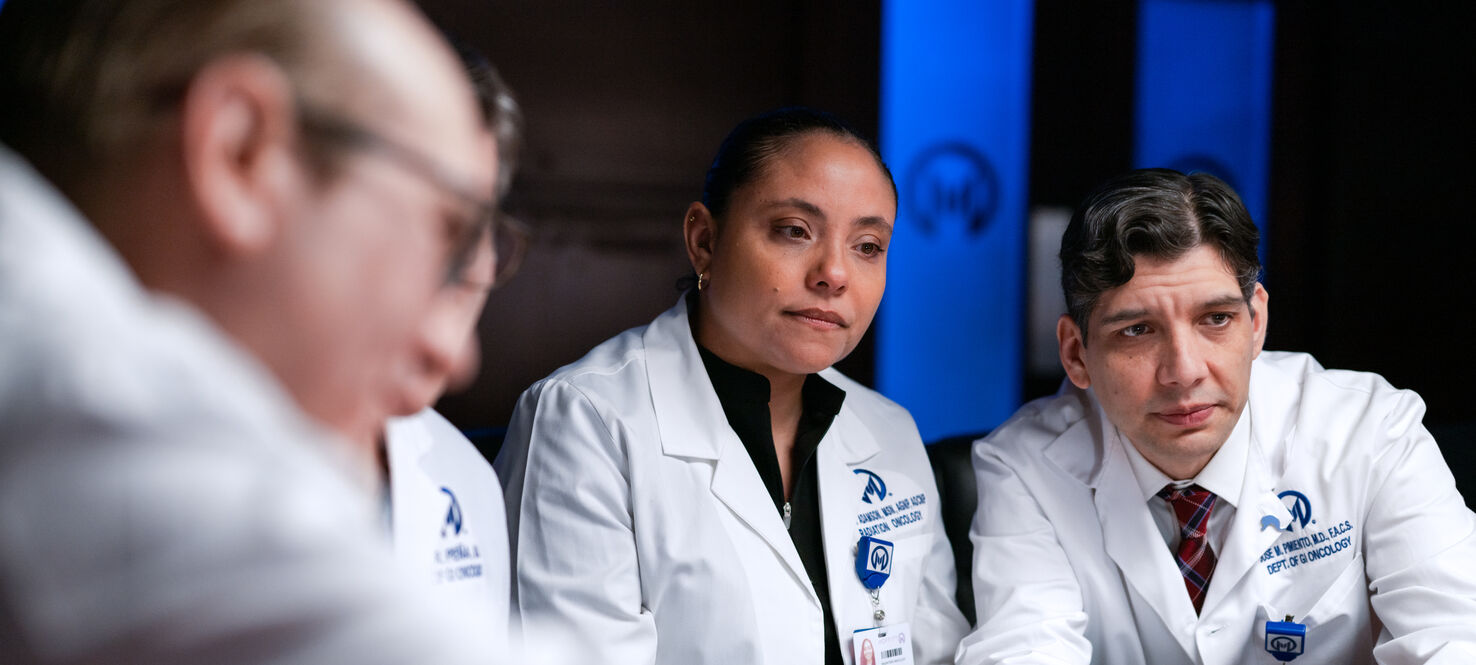 Jose Pimiento, MD, right, looks at a patient's case during the GI tumor board meeting.