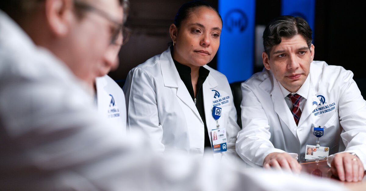 Jose Pimiento, MD, right, looks at a patient's case during the GI tumor board meeting.