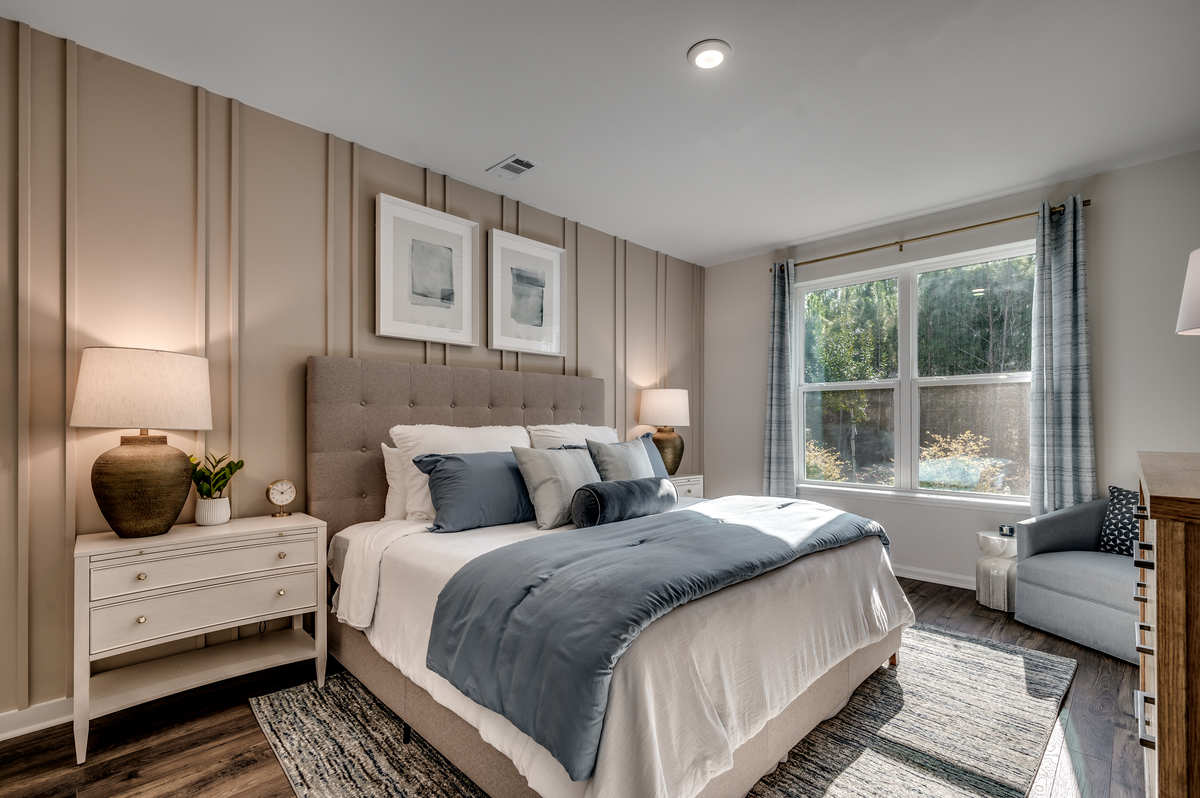 tan accent wall, large windows and hardwood floors
