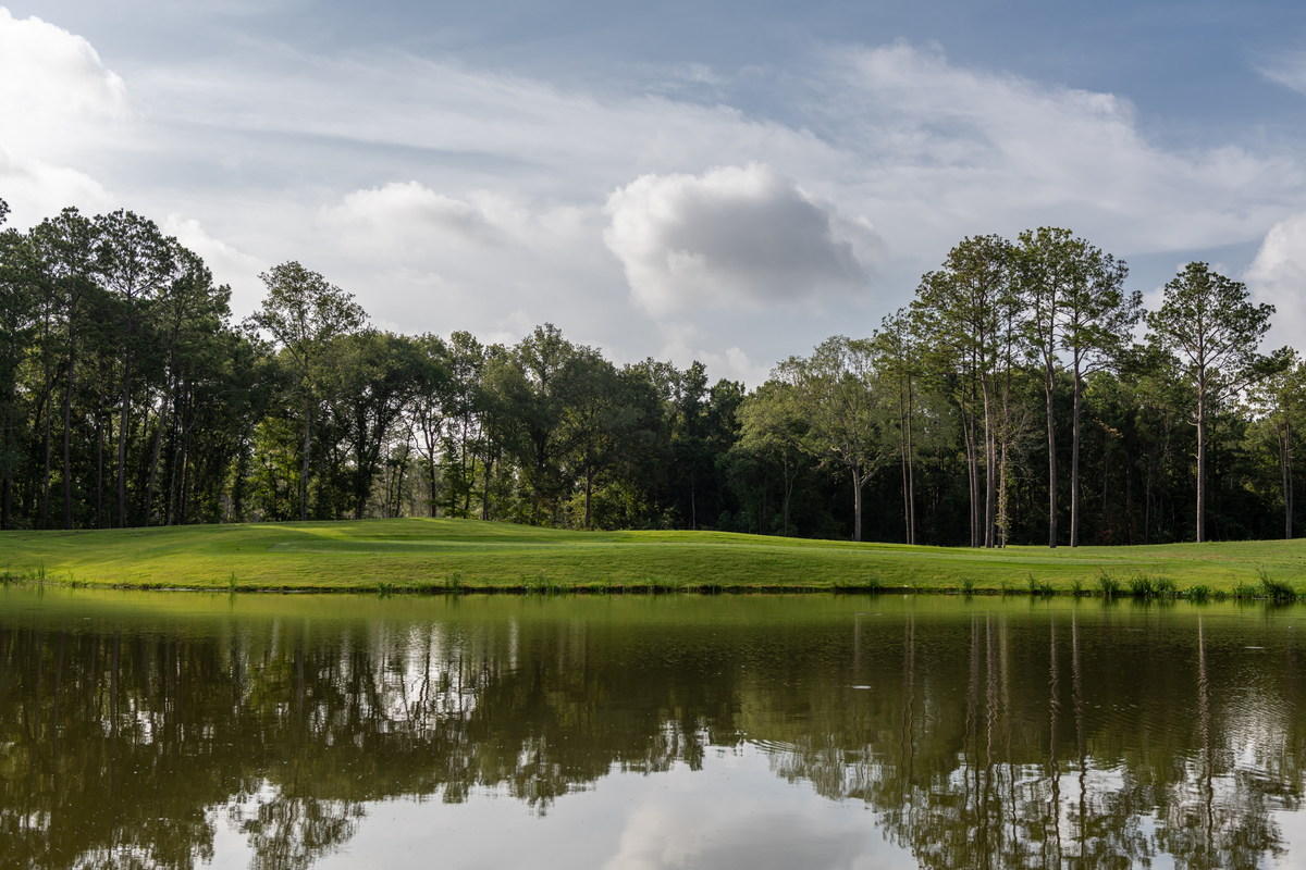 golf course next to water and wooded area