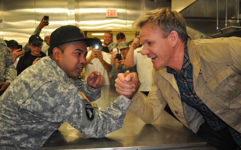 Celebrity chef Gordon Ramsey, right, arm wrestles with a member of the US Army.