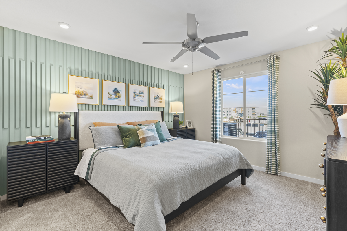 primary bedroom with green accent wall and bed