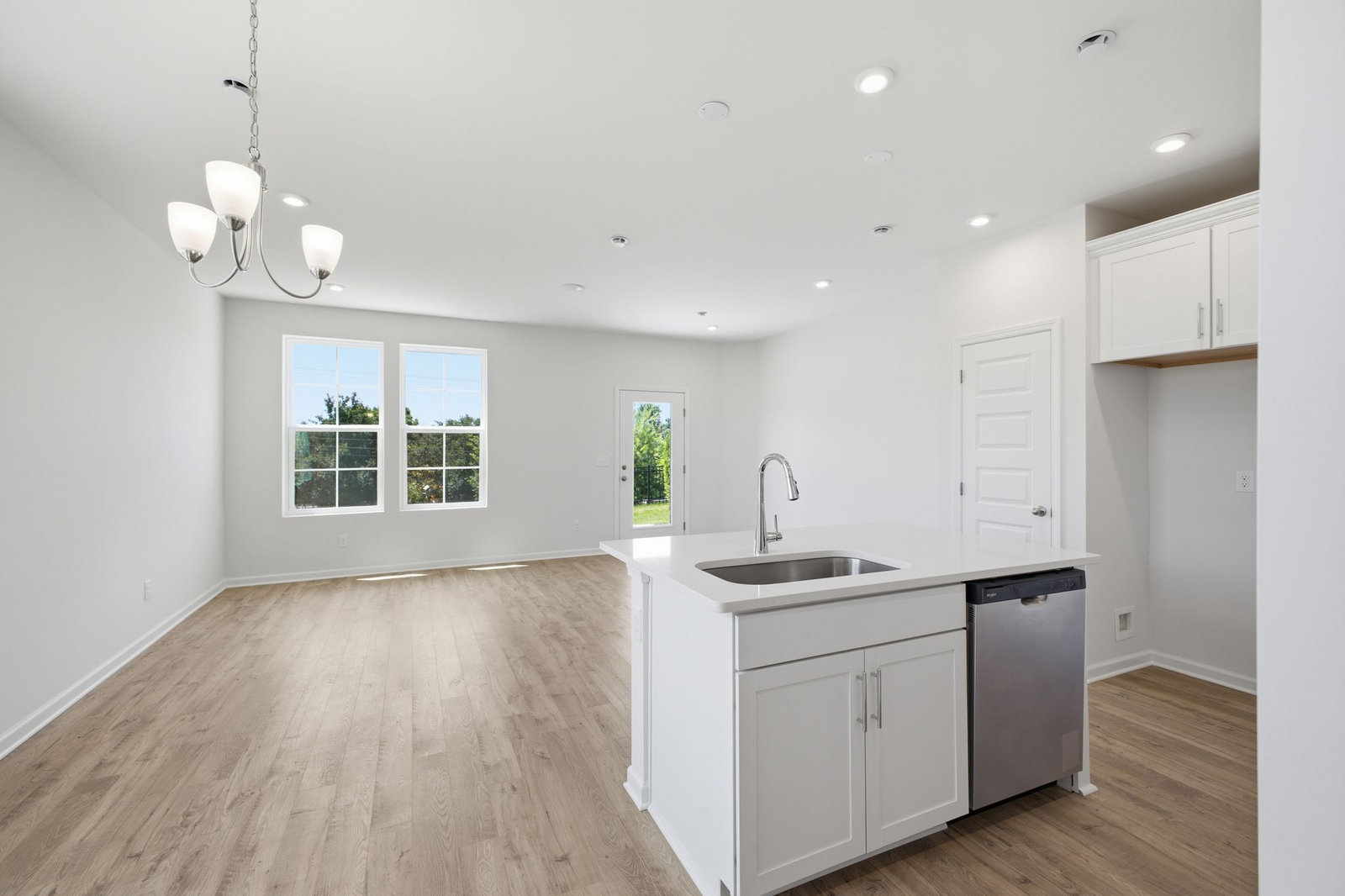 kitchen with white cabinets and counters, wood floors, and stainless steel appliances