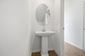 secondary bathroom powder room with standing sink and oval window