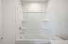 secondary bathroom with large tub, single-sink vanity with white counters and cabinets, polished chrome hardware