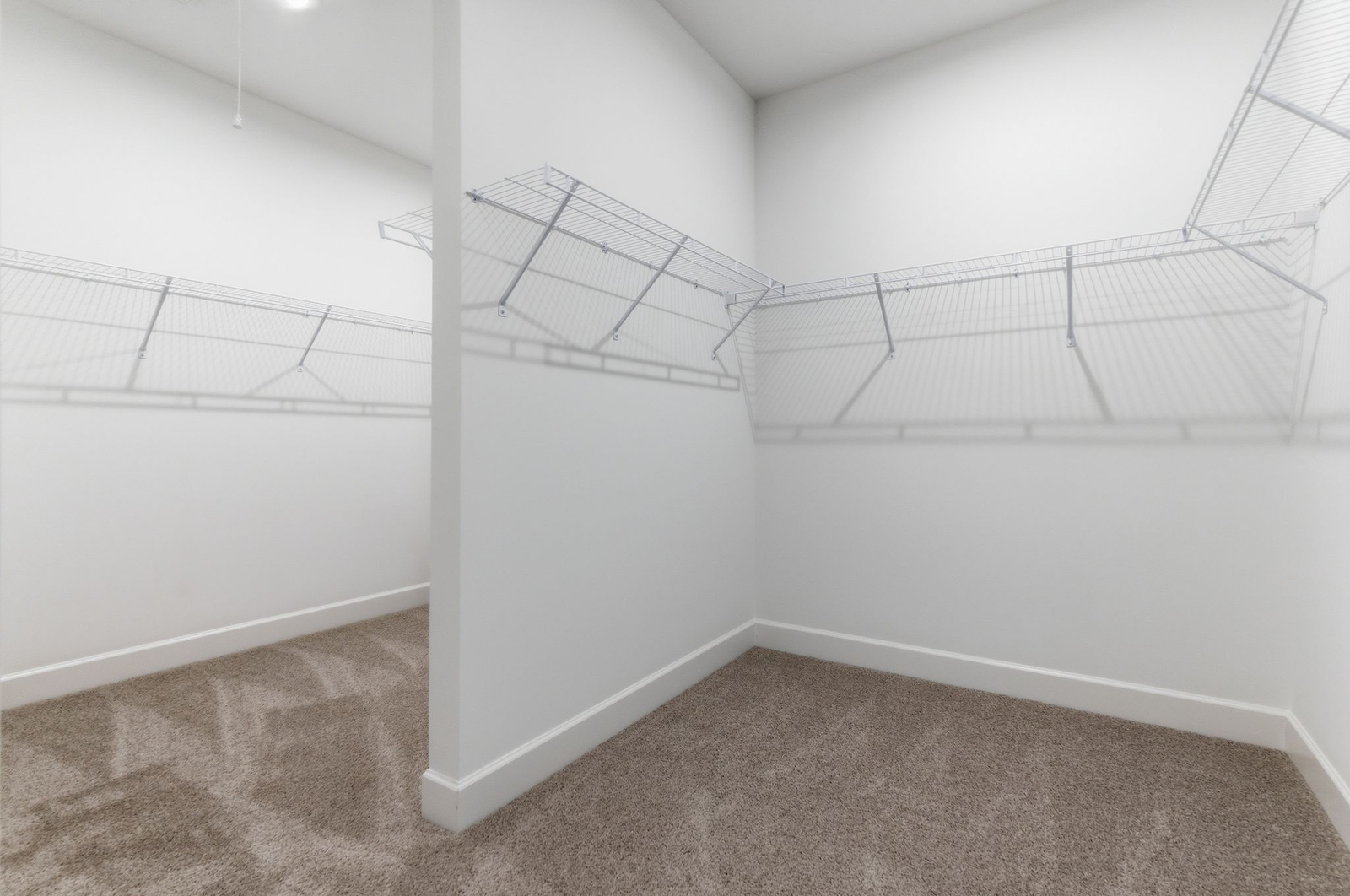 walk in closet with carpet, built-in shelving, and a half-wall divider