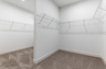 walk in closet with carpet, built-in shelving, and a half-wall divider