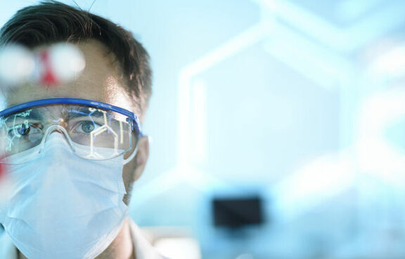 Scientist in a lab with goggles and face mask