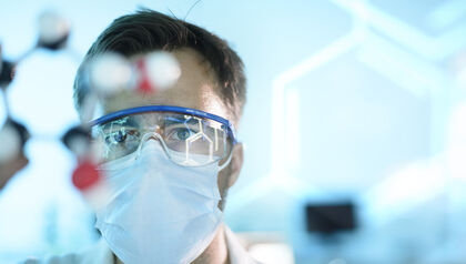 Scientist in a lab with goggles and face mask