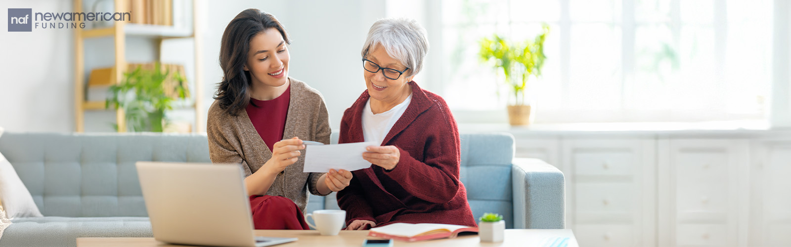 A younger woman and an older woman look at a document together.