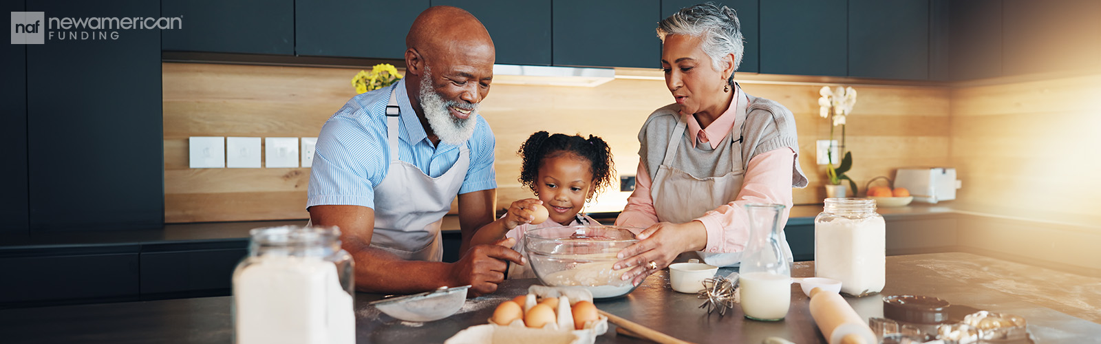 A older Black man and woman stand in a kitchen helping a young Black girl cook
