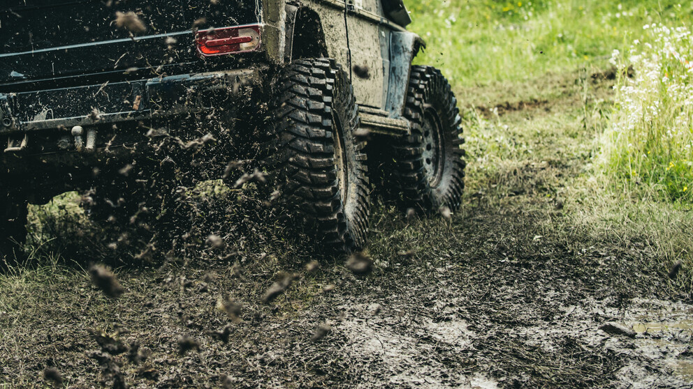 Four wheel drive car driving off-road in mud