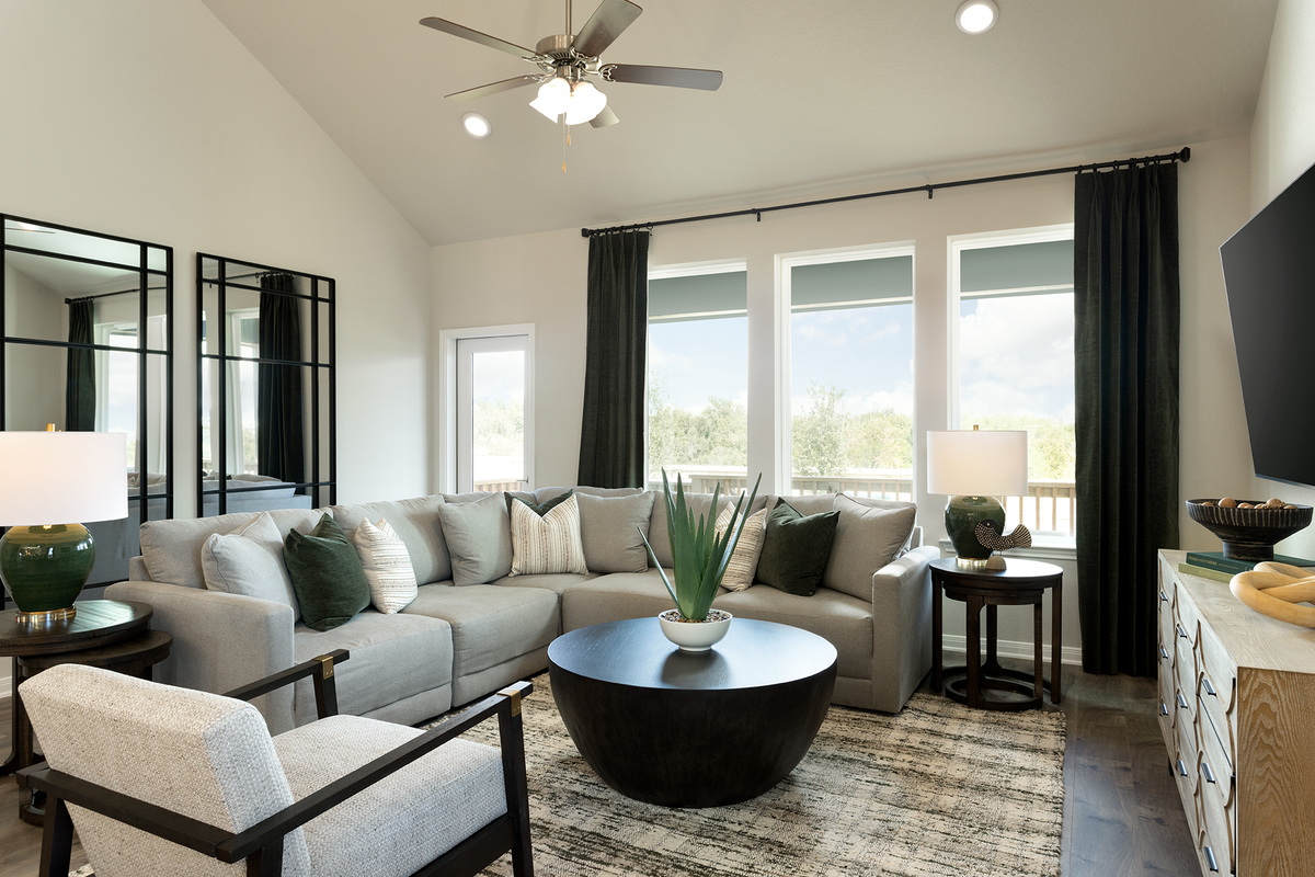 great room with gray couches, tv & windows 