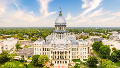 Illinois State Capitol building surrounded with green trees and gardens