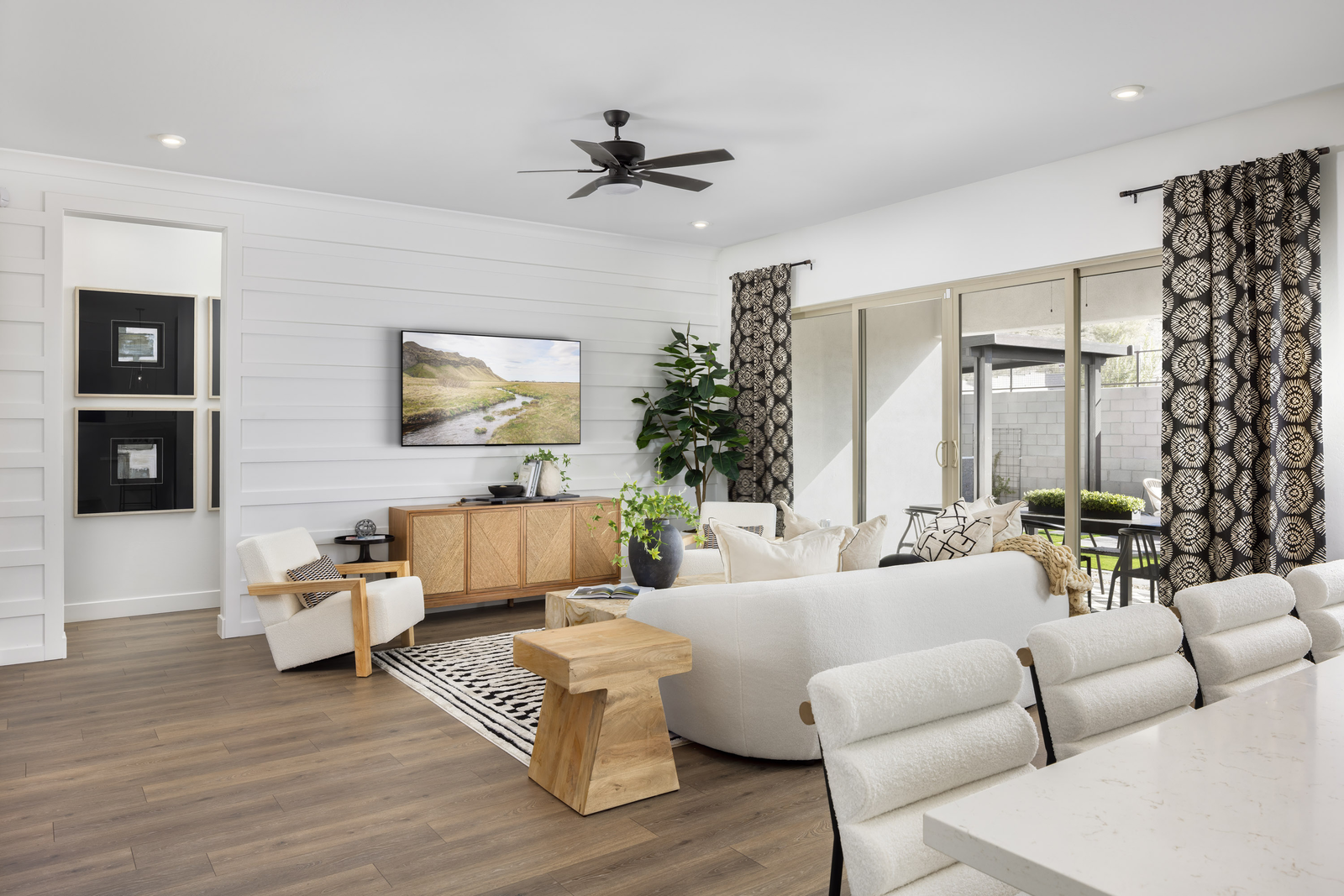 open-concept space with a large white couch, white accent chairs, and a wooden coffee table